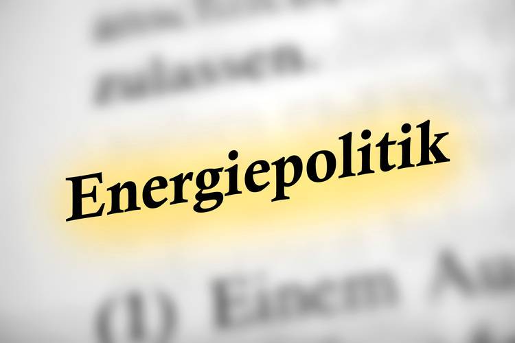 Alt-Text: „Das Wort ‚Energiepolitik‘ in gelber Schrift auf unscharfem Hintergrund, symbolisiert die Bedeutung von Strategien zur Steigerung der Energieeffizienz und Integration erneuerbarer Energien in der Gebäudetechnik.